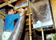 Picture of an FSEC researcher working on duct work.