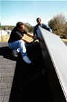 Picture of J. Harrison and P. Robinson installing a solar thermal collector.