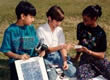 Photo of three kids using photovoltaic panel.