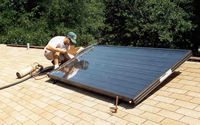Picture of a man installing a solar thermal collector on a residential roof.