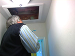 photo: man looking up into attic access hole