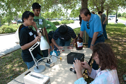 Photograph of students racing fueling the model fuel-cell car.