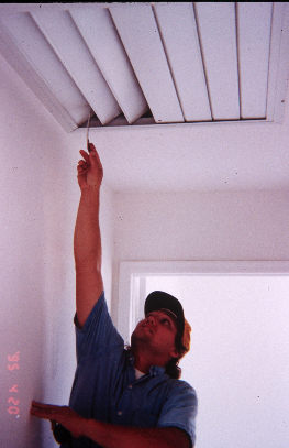 Photo of man opening ac vents with stick.