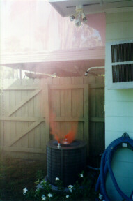 Photo of outside AC unit with colored smoke coming out.