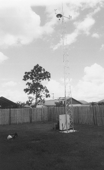 Photo of tower in fenced in backyard.