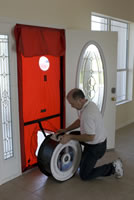 Picture of FSEC research setting up a blower door at the front door of a residential house.