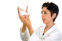 Picture of Nahid Mohajeri looking at a beaker.