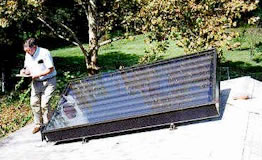 Picture of an inspector looking of a SWAP solar thermal collector.